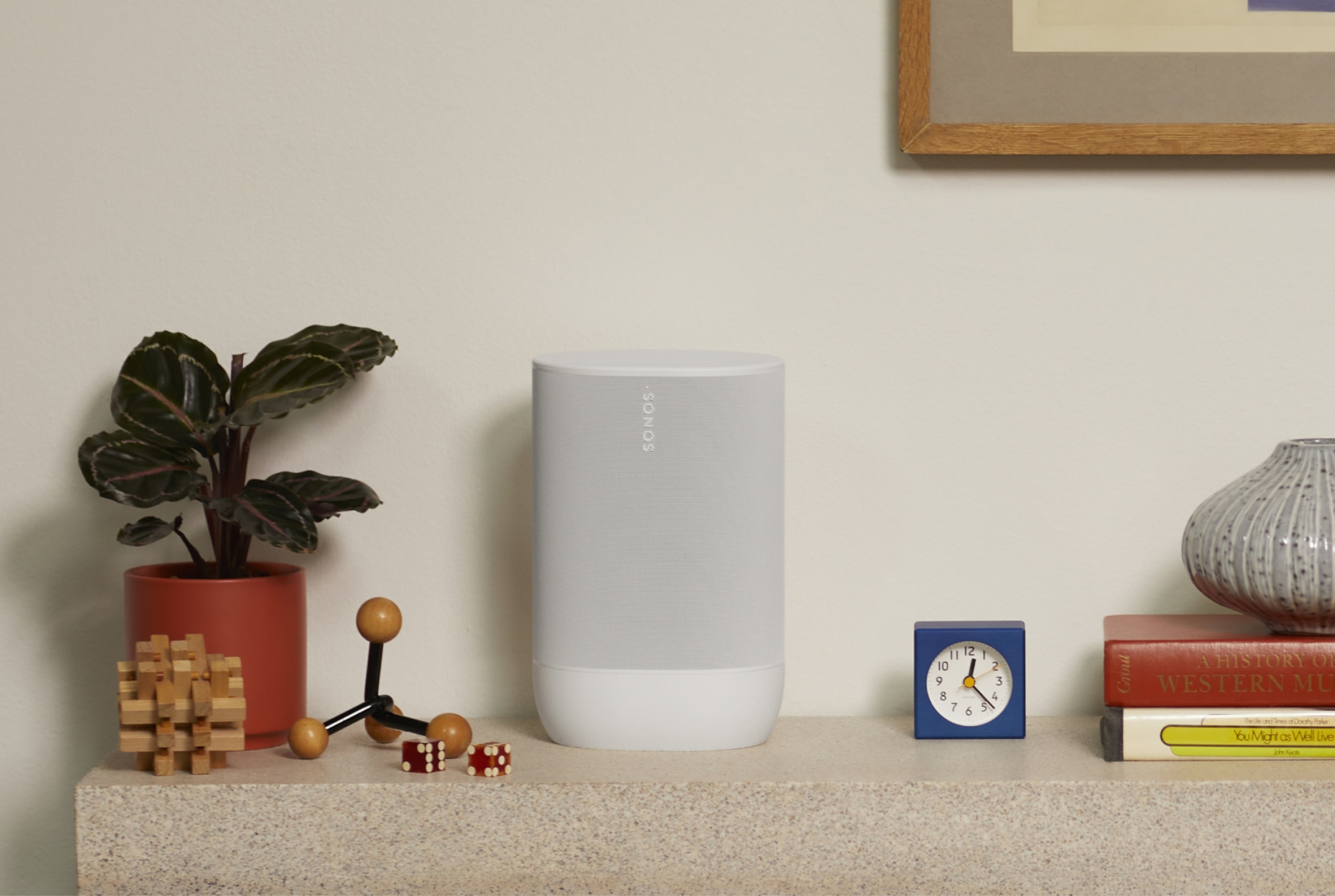 Valkoinen Sonos Move 2 sivupöydällä kasvin vieressä