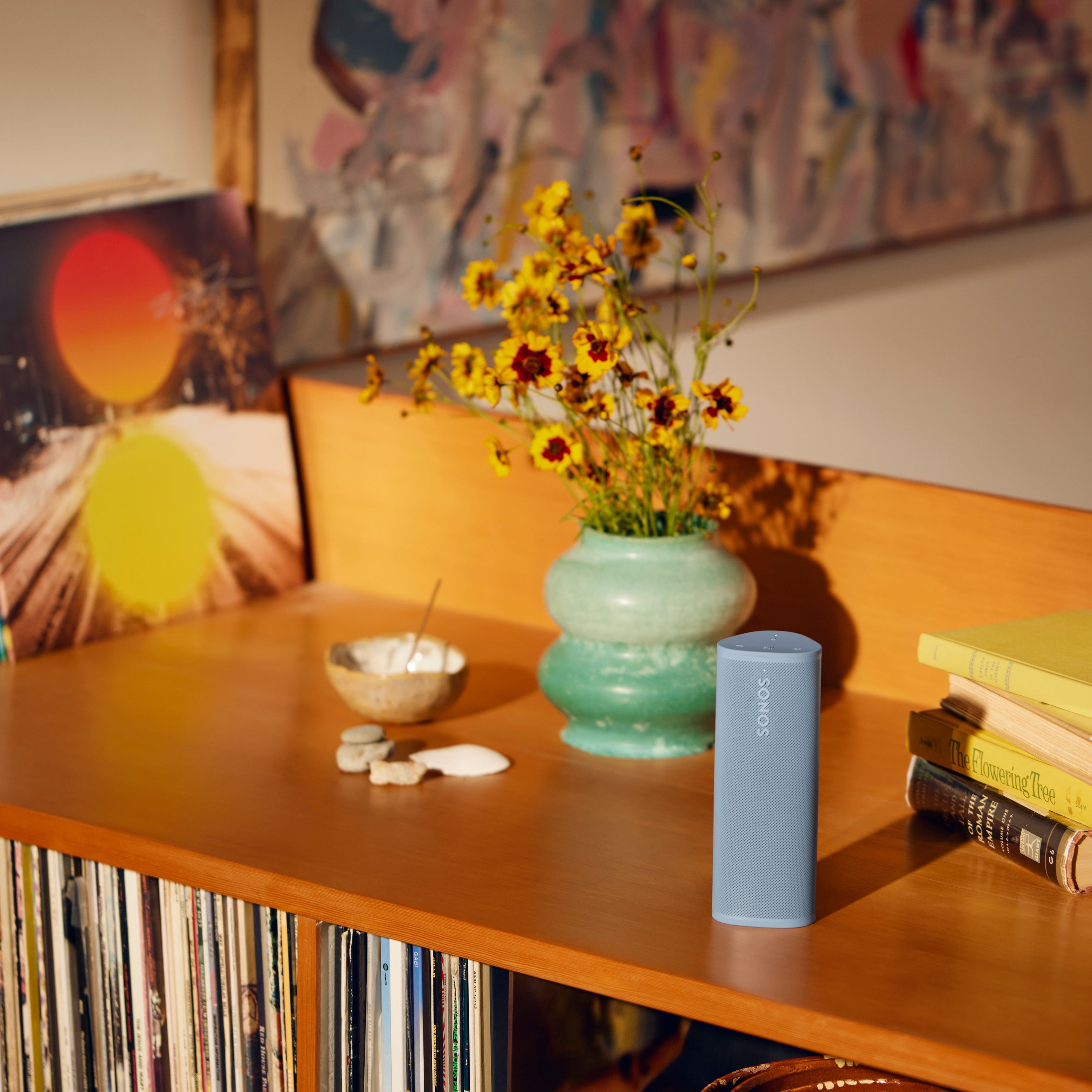 Roam 2 Wave on top of a bookshelf next to a flower vase