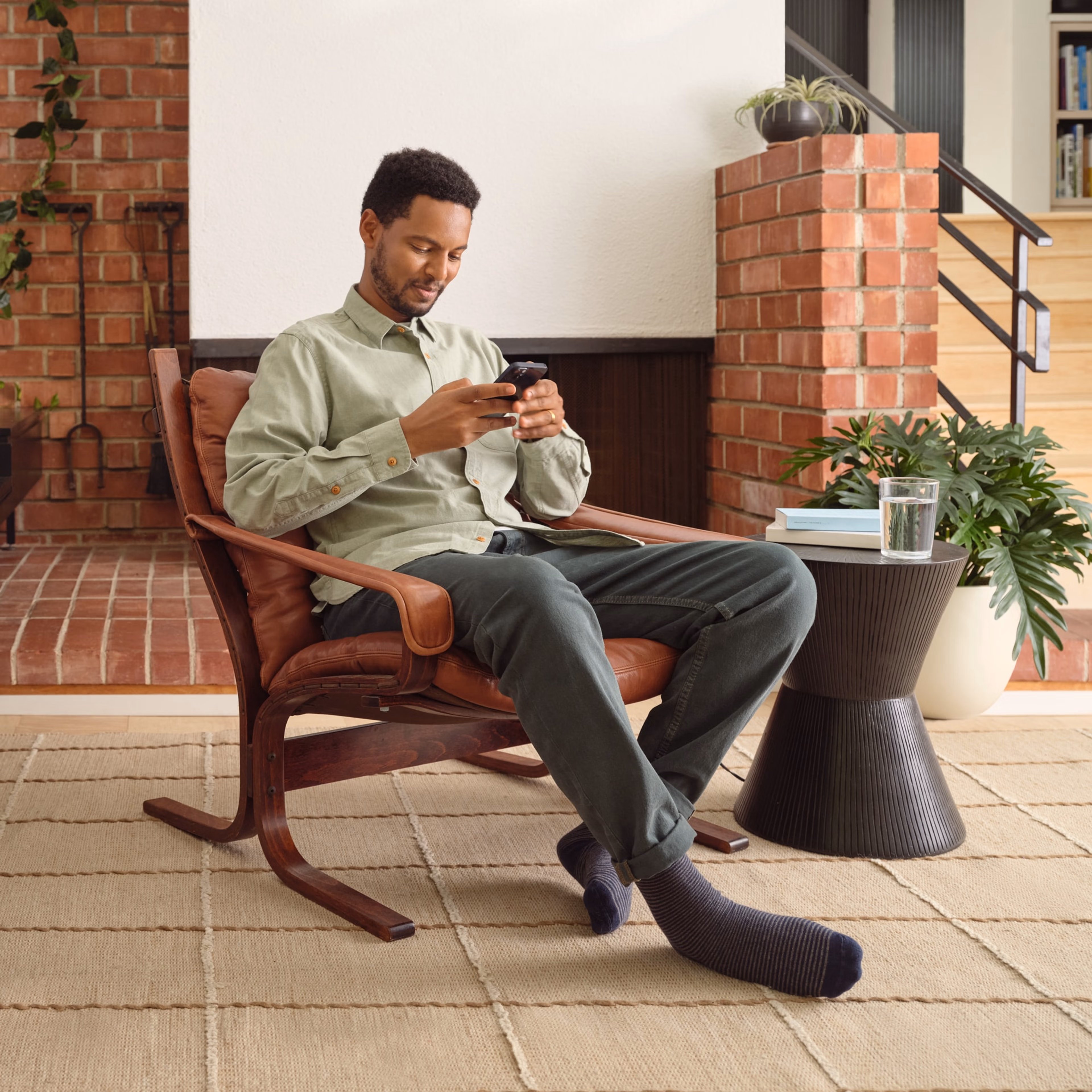 Utilisateur de Sonos assis, contrôlant Sonos sur son téléphone