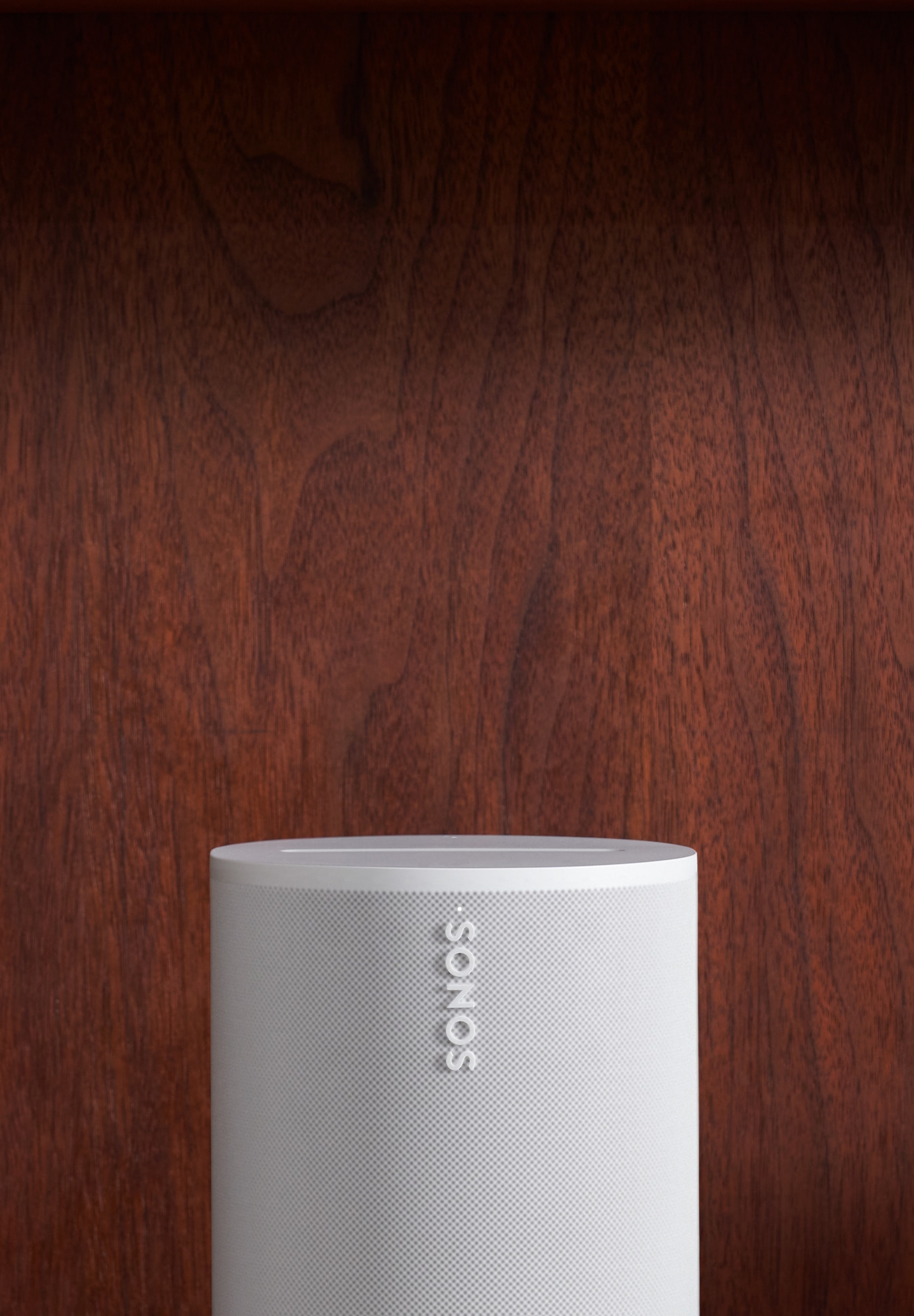 A white Era 100 speaker on a bookshelf