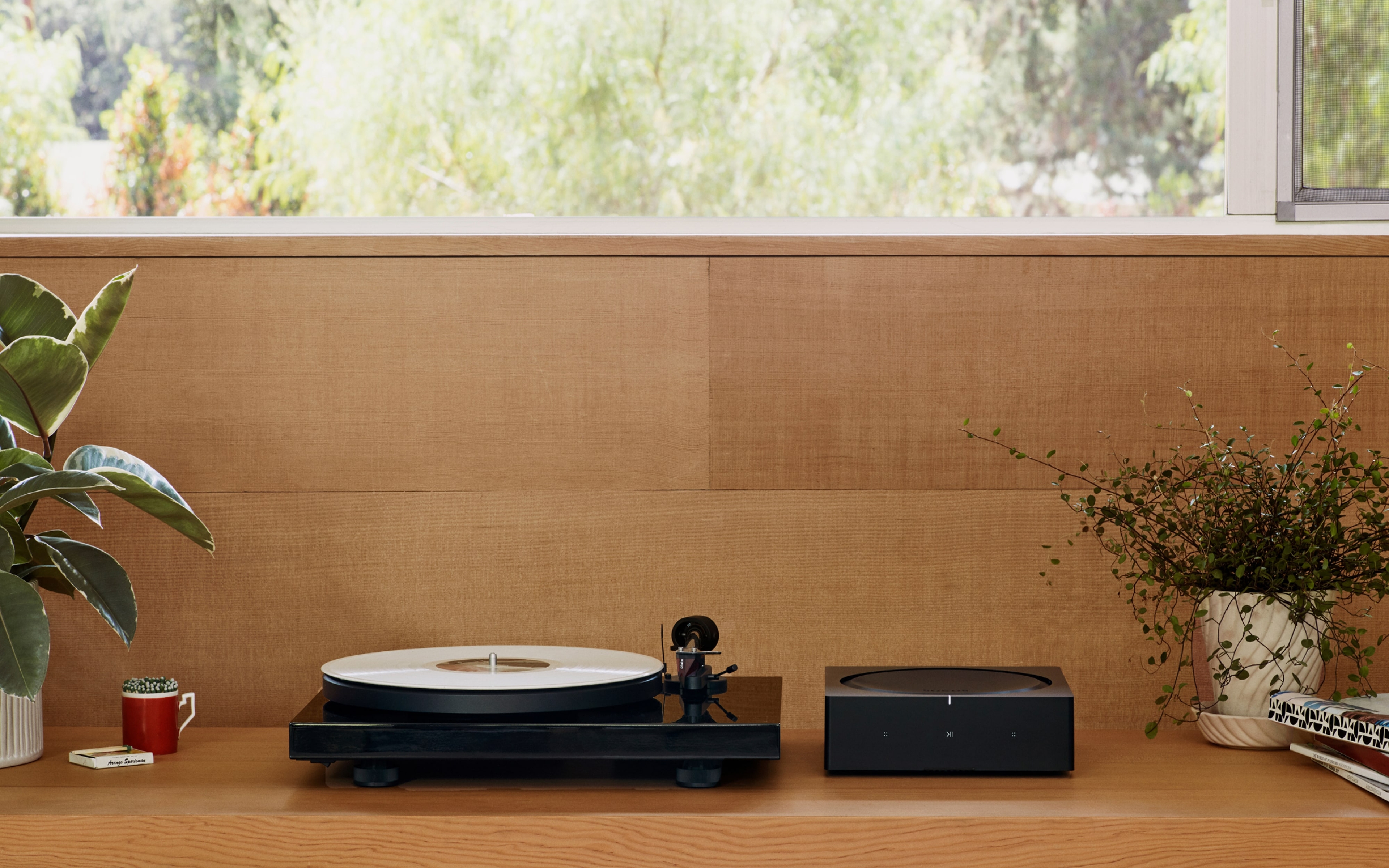 窗台下方书架上的Sonos Amp与唱机