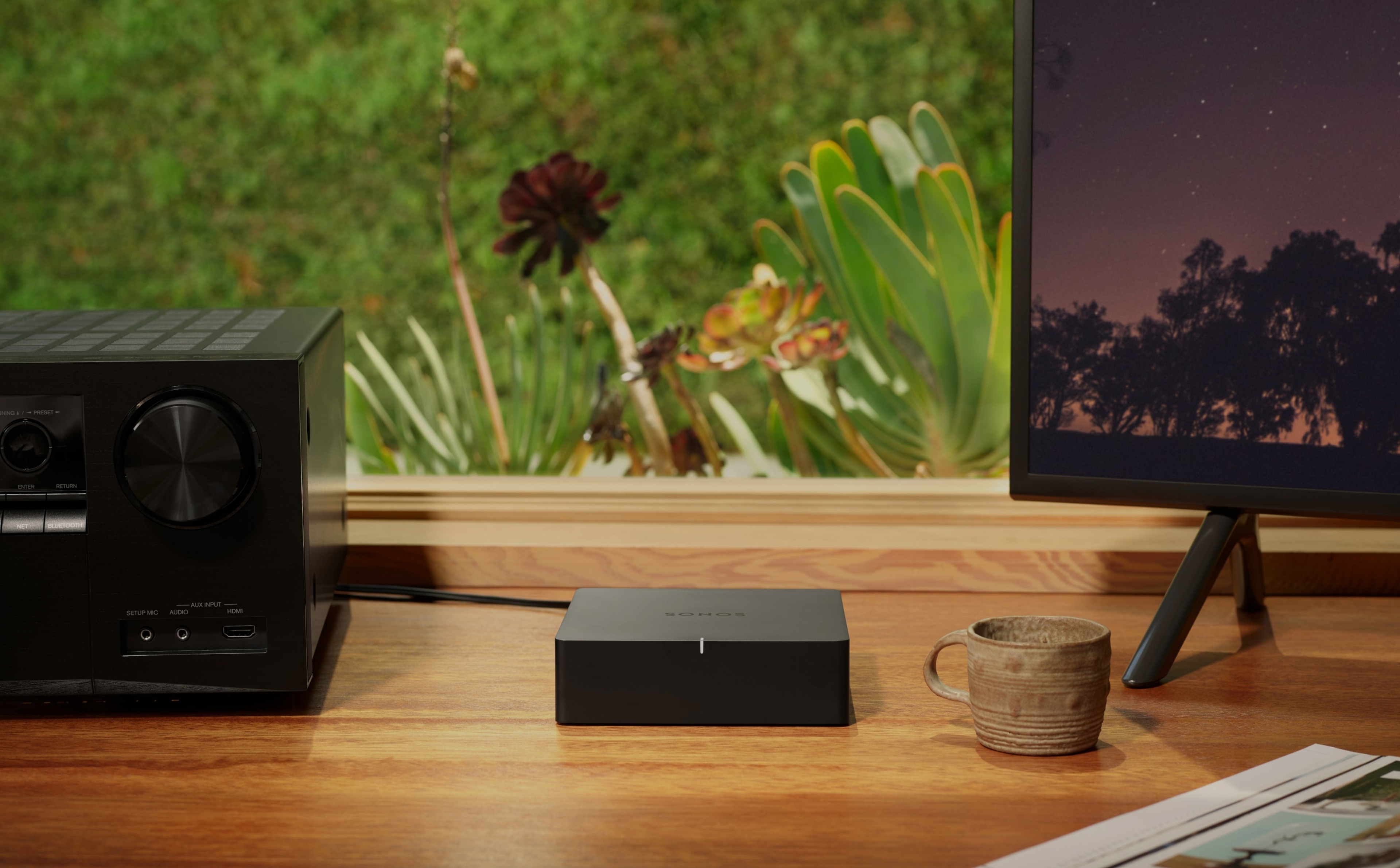 Sonos Port en un escritorio junto a un receptor estéreo