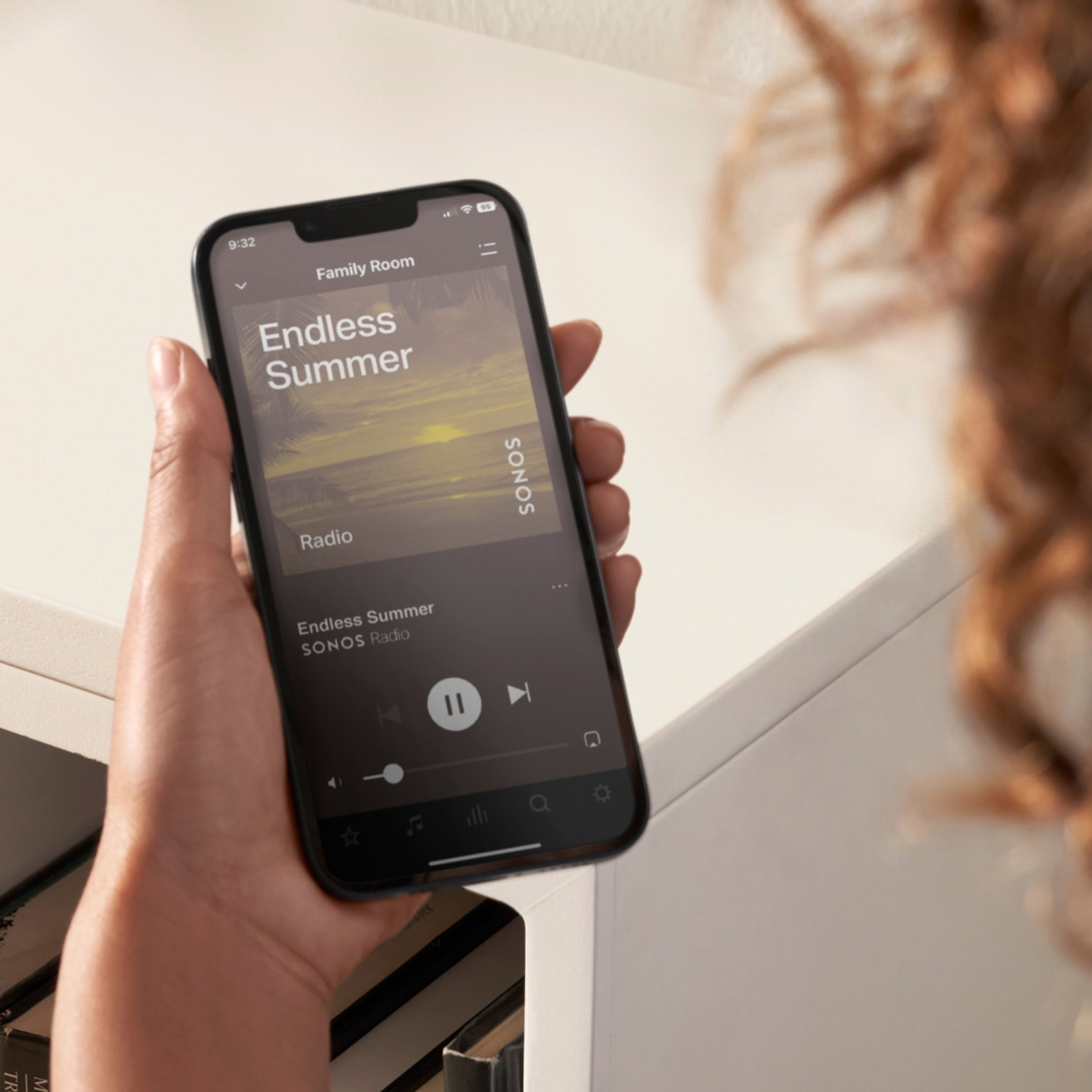 Lähikuva käyttäjän puhelimesta, kun hän käyttää Sonos-sovellusta hallitakseen Sonos-järjestelmää